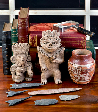 Antique Pre Columbian colection on table with old books.