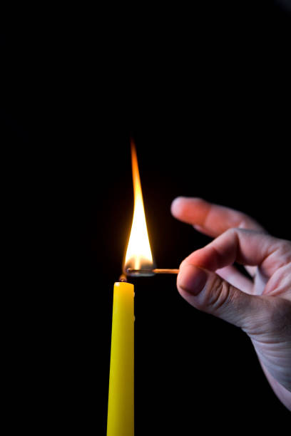 istock A man's hand lights a candle in the dark. 954723250