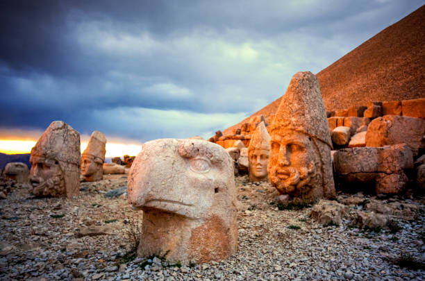 Nemrut Dagh The grave, monumental sculptures and unique landscape of the Antiquech I of Antiochos, King of Kommagene, who ruled on the slopes of Mount Nemrut at 2150 meters high in Kahta District of Adıyaman, is one of the most spectacular remains of the Hellenistic Period. Monumental sculptures spread to the eastern, western and northern terraces. The eastern terrace is the sanctuary and for this reason the most important sculptures and architectural remains are here. The well preserved giant sculptures are made of limestone blocks and are 8-10 meters high. nemrut dagi stock pictures, royalty-free photos & images