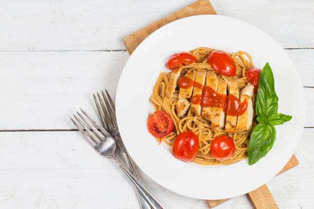 makaron spaghetti z kurczaka na białym drewnianym tle z włoskim jedzeniem. - italian cuisine linguini chicken pasta zdjęcia i obrazy z banku zdjęć