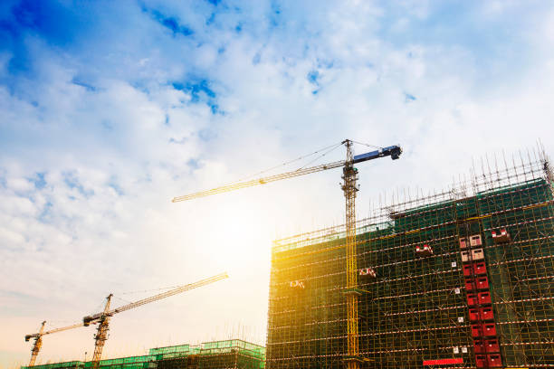 istock Crane and building construction site against blue sky 954732408