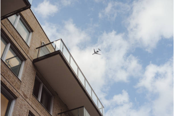 istock airplane in sky with residential buildings infront 954732592