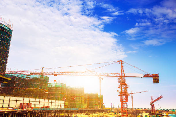 istock Crane and building construction site against blue sky 954732606