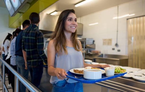 istock Happy woman with her tray at a self service restaurant 954735648