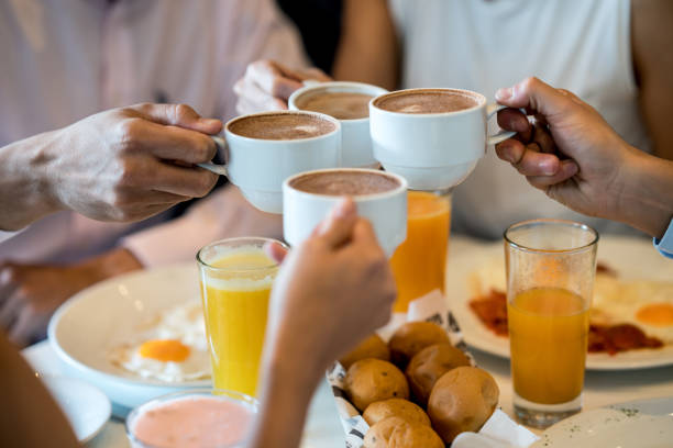 istock Unrecognizable group of people making a toast at breakfast with hot chocolate 954735682