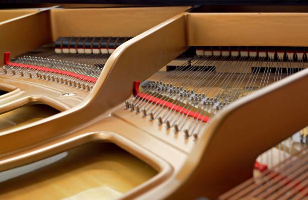 istock Inside a piano playing, dampers, felt hammers, action, metal strings and metal frame, red and white felt closeup 954736230