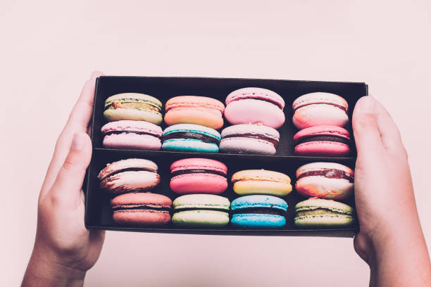 istock Tasty different colored macarons in black box on white background. 954746232