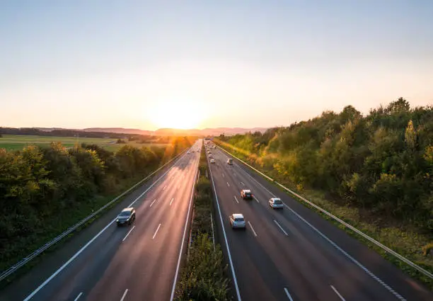 The road traffic on a motorway at sunset .