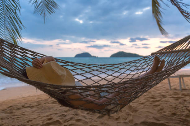 istock Happy woman relaxing in hammock 954752454