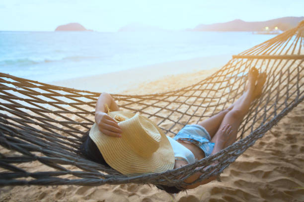 istock Happy woman relaxing in hammock 954752474