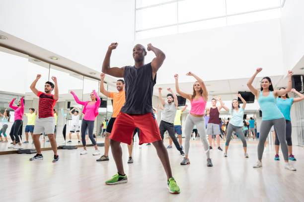 groupe diversifié de personnes à une leçon de la rumba dans le gymnase - fitness dance photos et images de collection