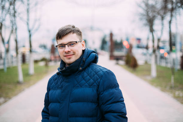 istock Portrait Of Smiling Man Standing On Footpath Against Sky 954755430