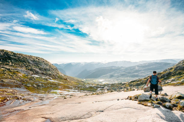 istock Rear View Of Man Climbing On Mountain Against Sky 954755502