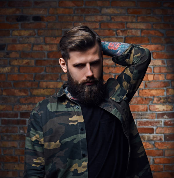 istock Tattooed bearded male in military jacket. 954759422