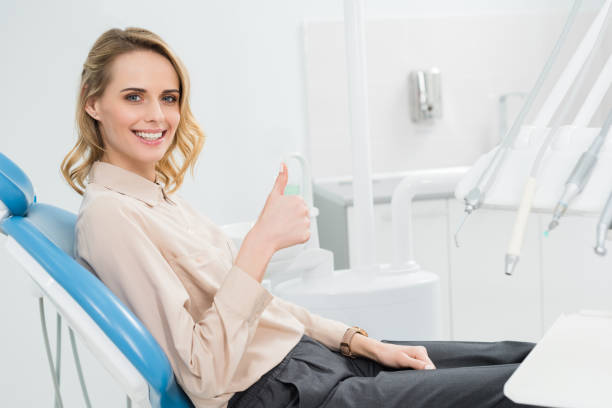 istock Young woman showing thumb up at check-up in modern dental clinic 954759708