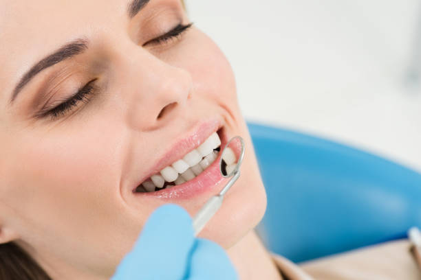 istock Doctor checking patient teeth with mirror in modern dental clinic 954760110