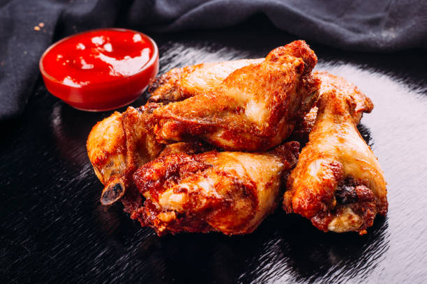 istock fried chicken on a black background and ketchup on the side 954760506
