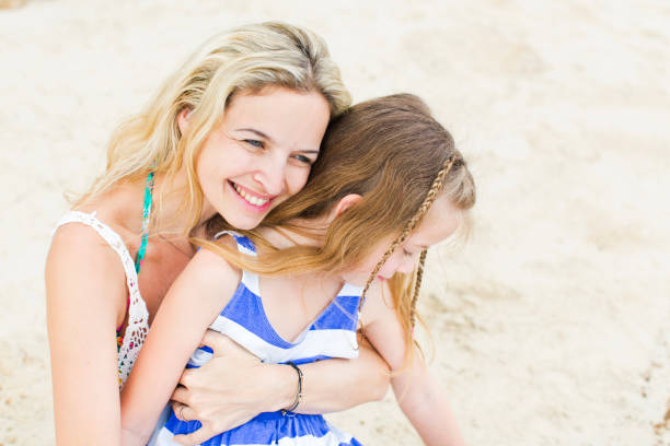 istock Smiling Mother With Daughter At Beach 954762808