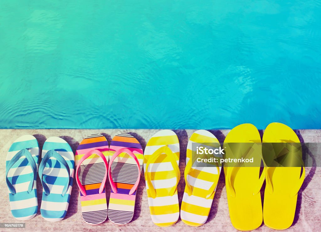 Flip flops on stone background Flip flops on stone background on poolside. Summer family vacation concept Summer Stock Photo