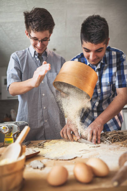 istock Kids Making pasta  in the kitchen 954767956