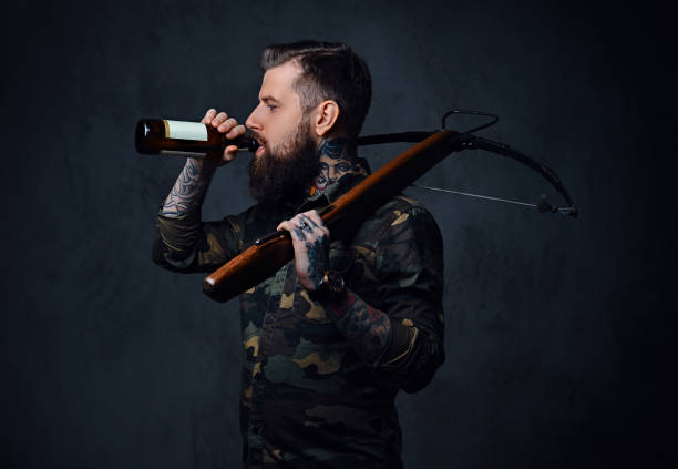 istock A man holds the craft beer bottle and a crossbow. 954768772