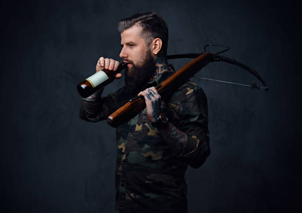 istock A man holds the craft beer bottle and a crossbow. 954773992