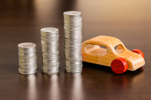 istock Stack of coins with wooden car on wood table 954776904