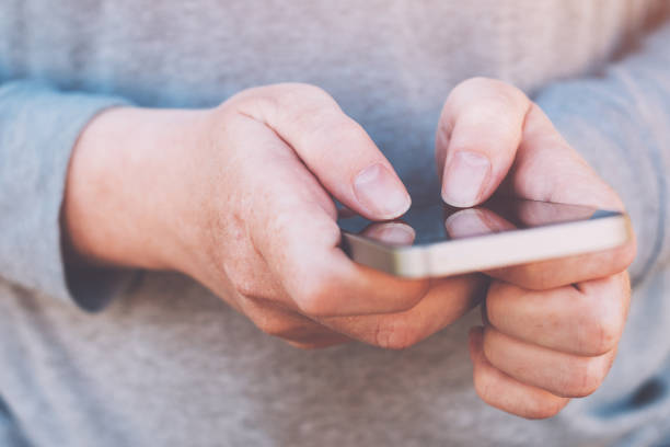 istock Close up of female hands using smartphone outdoors 954779122