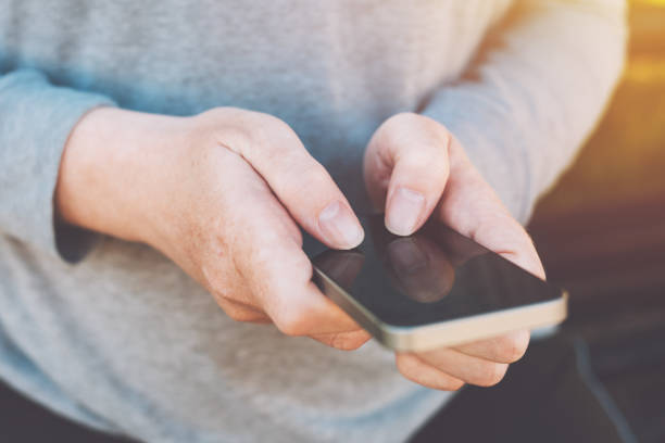 istock Close up of female hands using smartphone outdoors 954779192