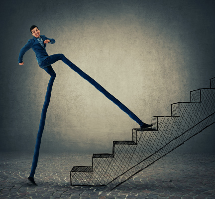 Businessman with long legs stepping on a staircase, trying to leap more stairsteps once. Accelerate climbing to success and bussiness growth.