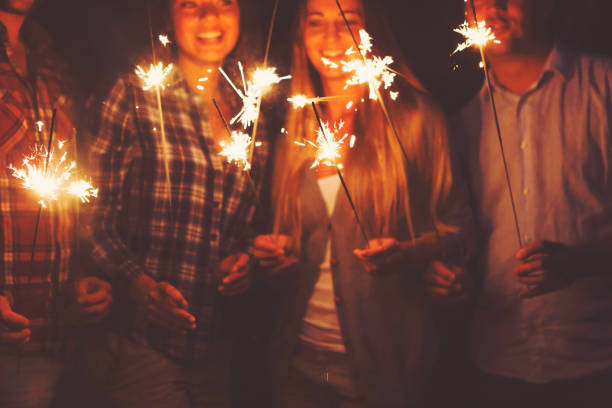 istock Young people with sparklers having fun on outdoor party 954784448