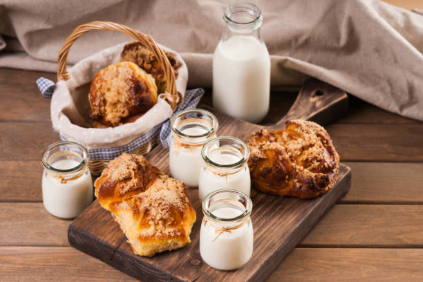 istock Bread buns, jars and bottle with milk,  on a cutting board 954788526