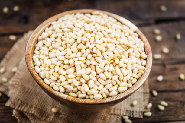 istock Shelled Raw Pine Nuts in the Wooden Bowl 954797360