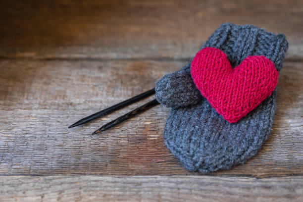 Knitted red heart on the handmade mitt, Valentine's Day postcard