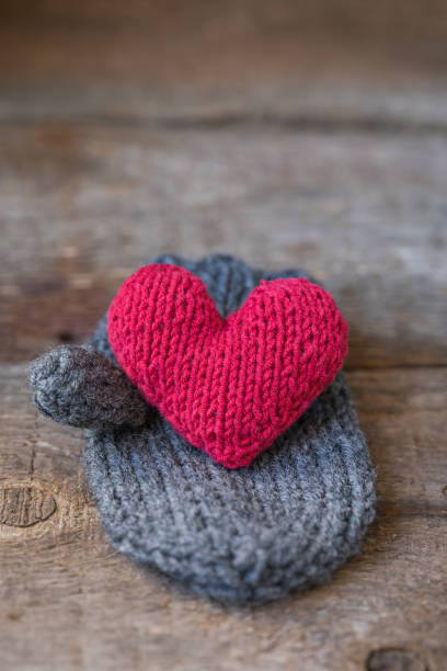 istock Knitted red heart on the handmade mitt, Valentine's Day postcard 954809284