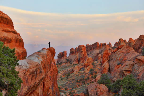 Hiker at the top of a summit in Arches National Park. Double O Arch Trail.