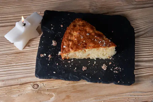 Photo of A piece of apple pie with grated chocolate near chocolate truffle candies. Selective focus and small depth of field.