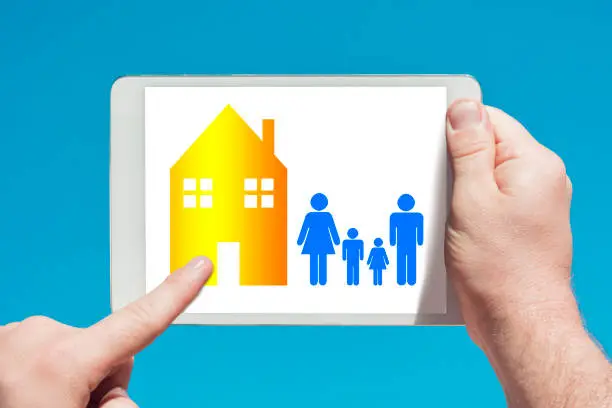 Photo of Man holding a tablet device showing family housing concept