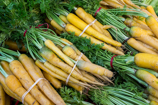 Close-up of organic carrots at outdoor farmer's market.