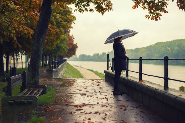 mujer de pie en la lluvia - grave nature usa city life fotografías e imágenes de stock