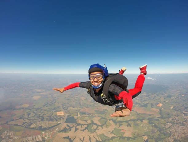 istock Smiling black woman jumping from parachute 954842152
