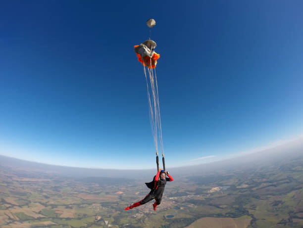 istock Smiling black woman jumping from parachute 954842220