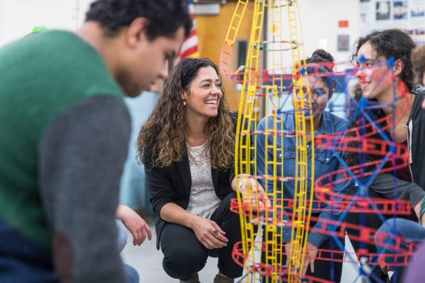istock Ethnic art teacher shows her class a colorful example of sculpture 954844240