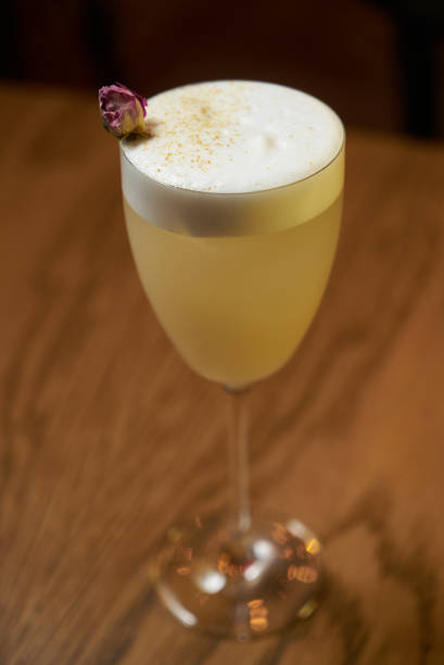 Glass with alcoholic cocktail drink on table