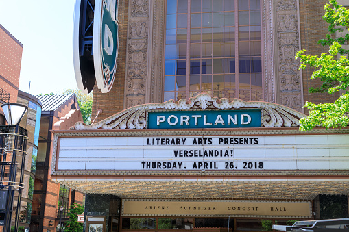 Portland, Oregon, USA - April 27, 2018 : Blue Portland sign on brick building from distance in Portland, Oregon, USA with clear blue sky