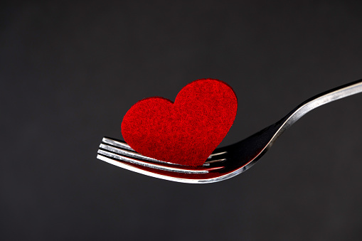 red heart shape in silver fork , romance love dinning or health heart care concept