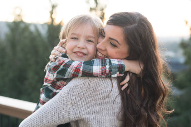 istock Mom holds her young daughter outside 954877012