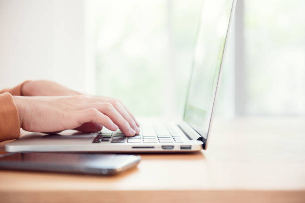 istock woman's hands typing on a laptop on a wooden desk. 954885196