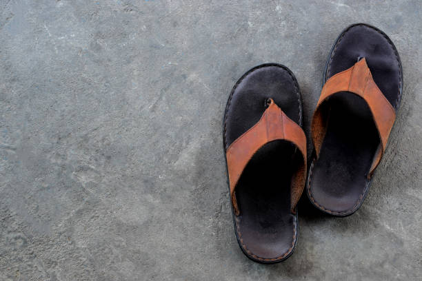 istock Men's sandals or flip flop on concrete floor 954888588