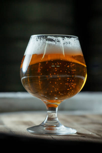istock Snifter beer glass on a wooden barrel 954893290